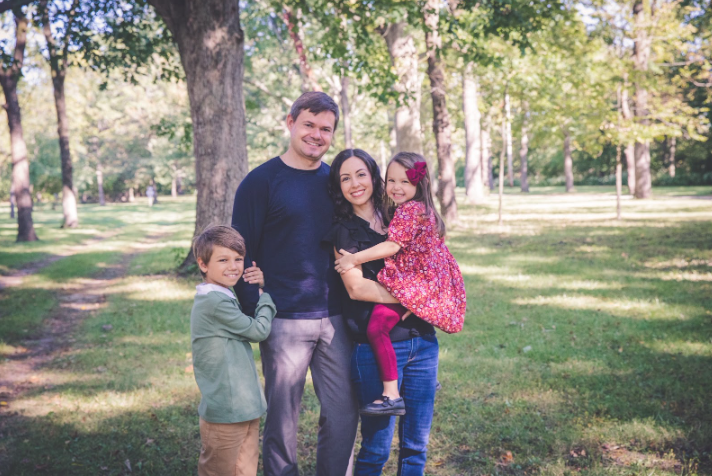  Srta. Hernández and her family posing for a photo. On the far left is her son, then her husband, Srta. Hernández, and her daughter. 
