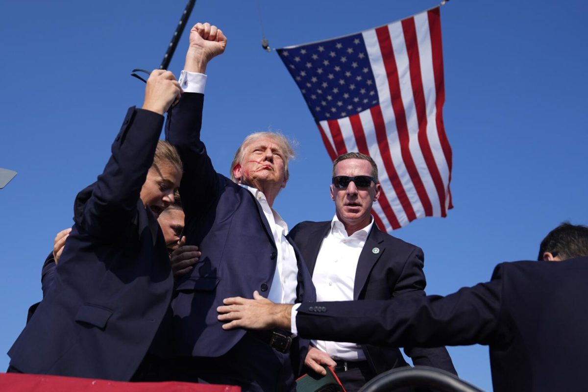 Trump raises his fist in the air after an assassination attempt.