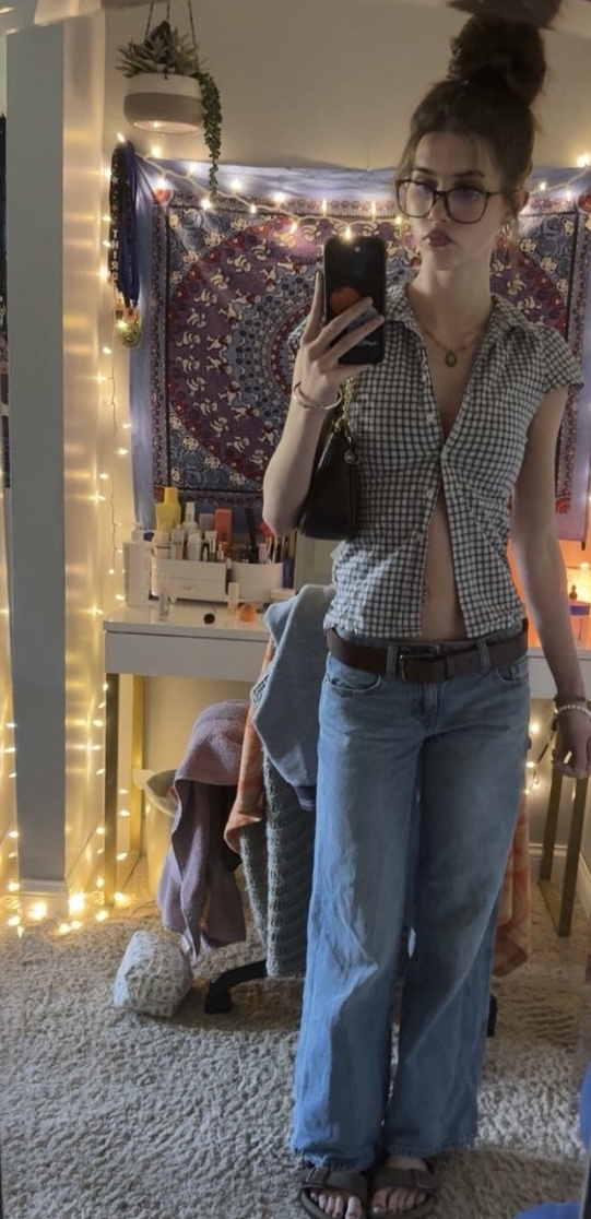 Ava Bozarth channeling early 2000s nostalgia with low-rise jeans, a croppedbutton down, and chunky accessories. 